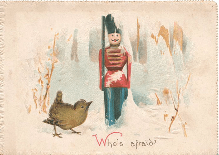 A wooden beef eater solider toy in the snow, while a sparrow looks up at him. The card reads "who's afraid?"